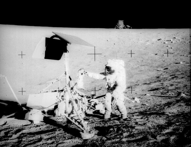 Pete Conrad standing at Surveyor 3, with the Lunar Module in the background